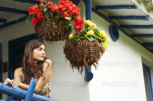 Hispanic girl leaning on porch railing