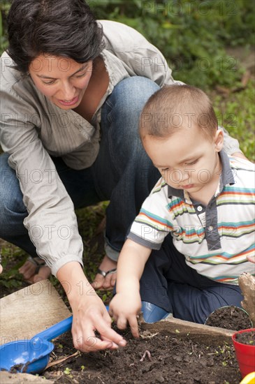 Hispanic mother gardening with son