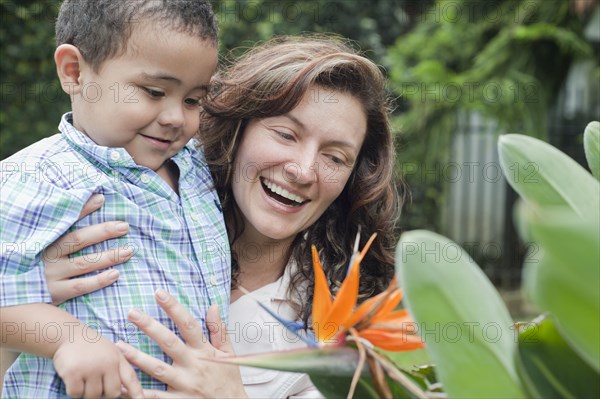 Hispanic mother showing flower to son