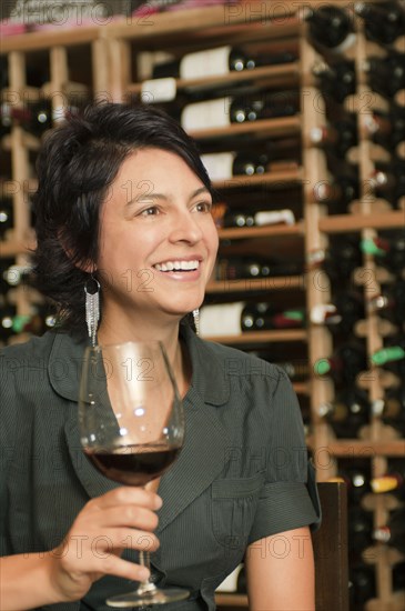 Hispanic woman drinking red wine