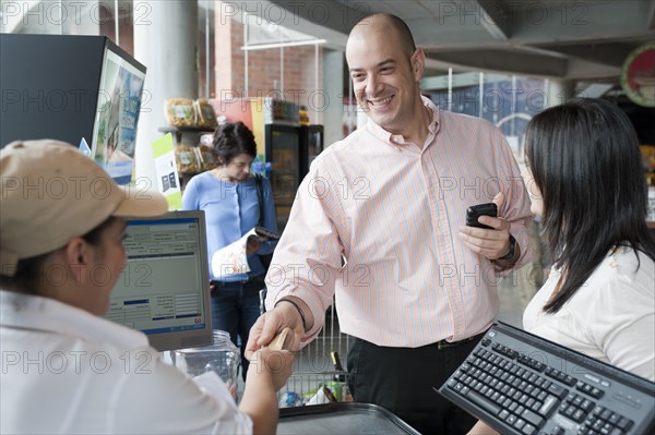 Hispanic man paying with credit card in store