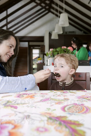 Hispanic woman feeding son