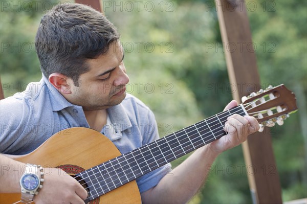 Hispanic man playing guitar