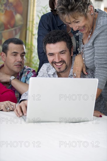 Hispanic family looking at laptop