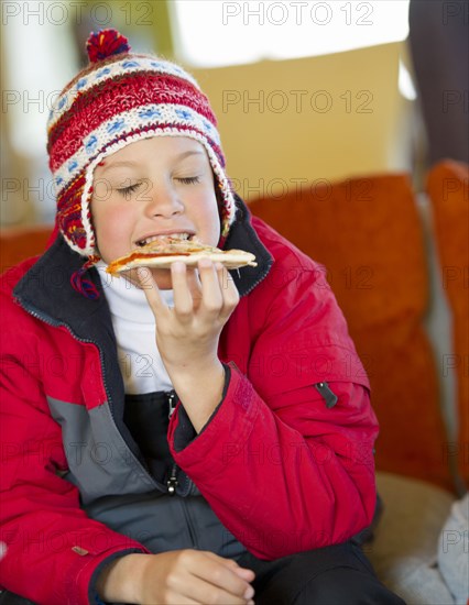 Hispanic boy eating pizza