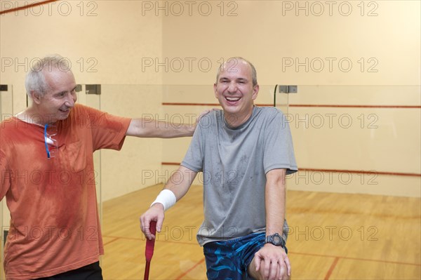 Hispanic men relaxing after racquetball