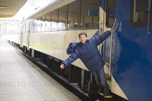 Hispanic boy standing on stairs of train