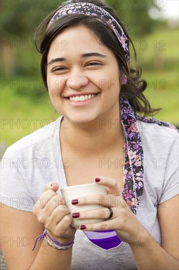 Smiling Hispanic woman drinking coffee