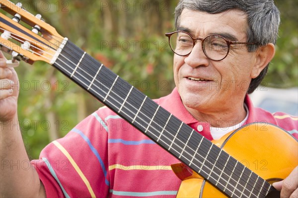 Hispanic man playing guitar