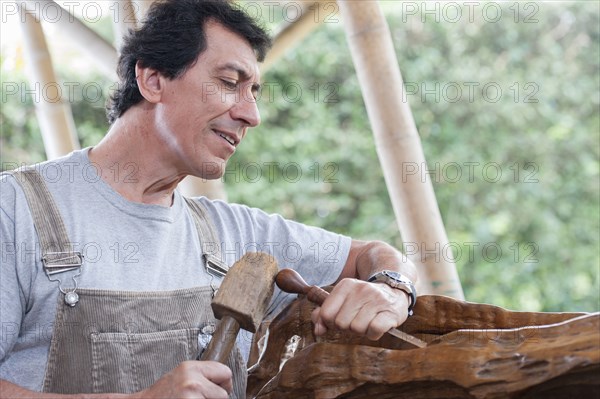 Colombian sculptor working on wood