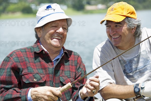 Hispanic men fishing in lake