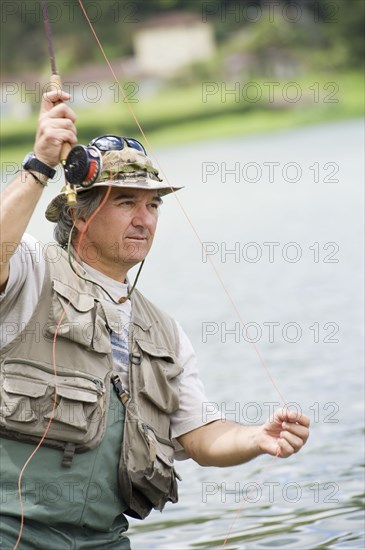 Hispanic man fishing in lake