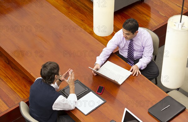 Hispanic businessmen having meeting in conference room