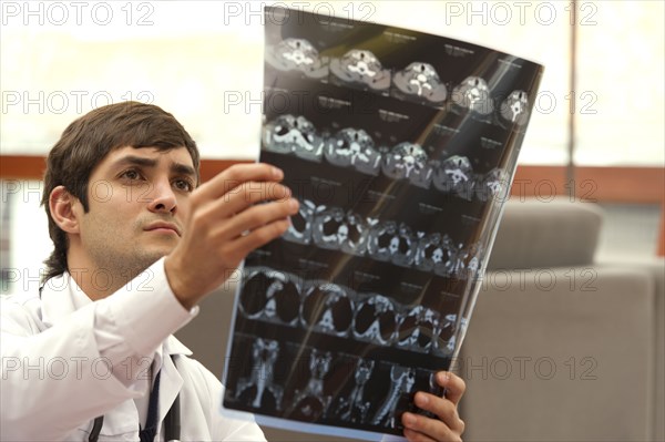 Hispanic doctor examining CAT scan