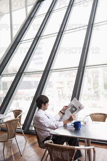 Hispanic businessman reading newspaper on break