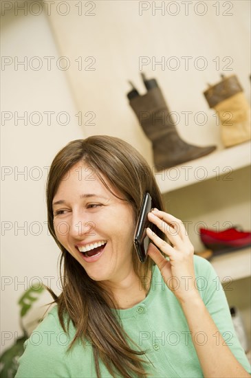 Hispanic woman talking on cell phone in shoe store