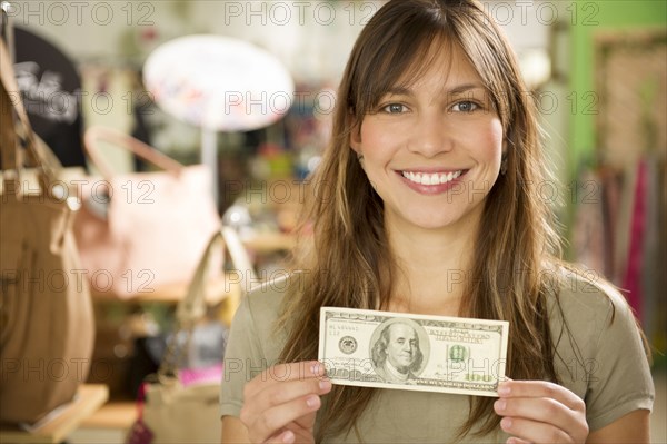 Hispanic woman holding cash in store