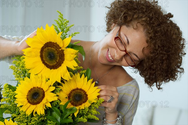 Hispanic woman arranging sunflowers