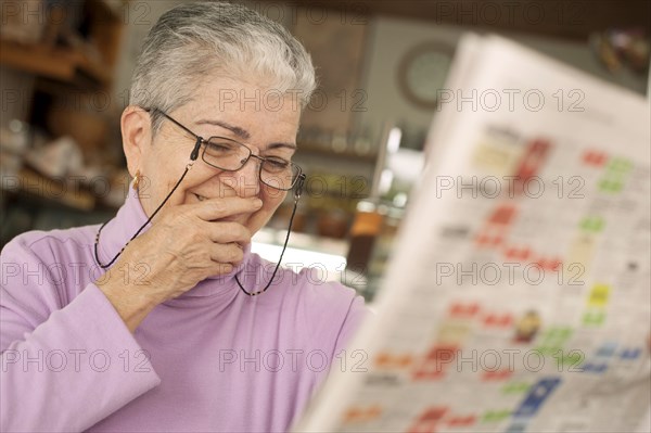 Hispanic woman reading newspaper