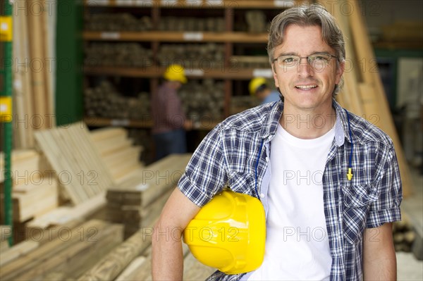 Hispanic carpenter holding hard hat