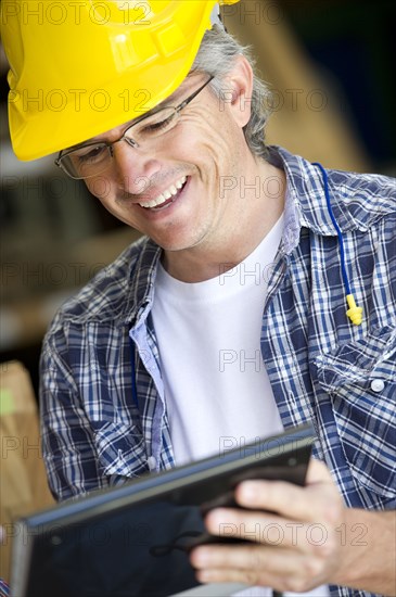 Hispanic carpenter using digital tablet