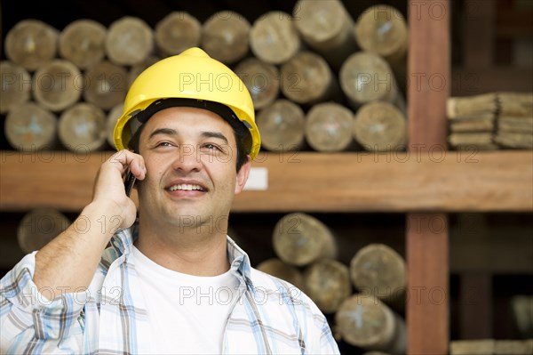 Hispanic carpenter talking on cell phone