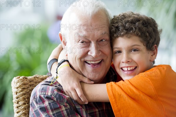 Hispanic boy hugging grandfather