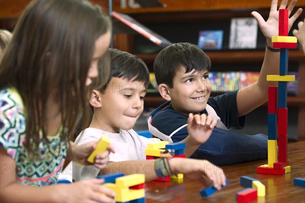 Hispanic students in library playing with blocks