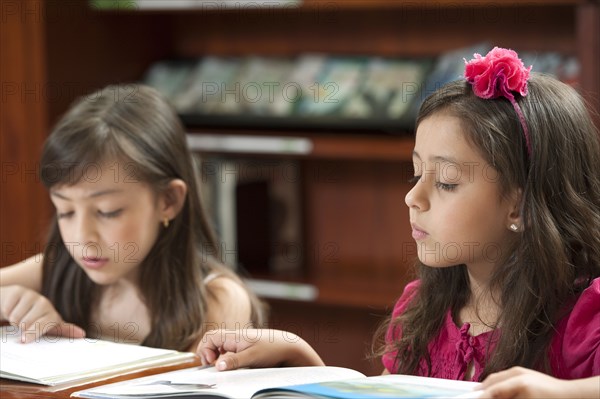 Hispanic girls reading in library