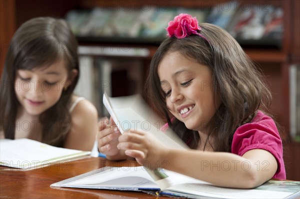 Hispanic girls reading in library