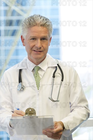 Caucasian doctor holding clipboard