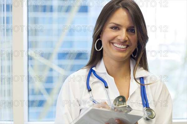Hispanic doctor holding clipboard