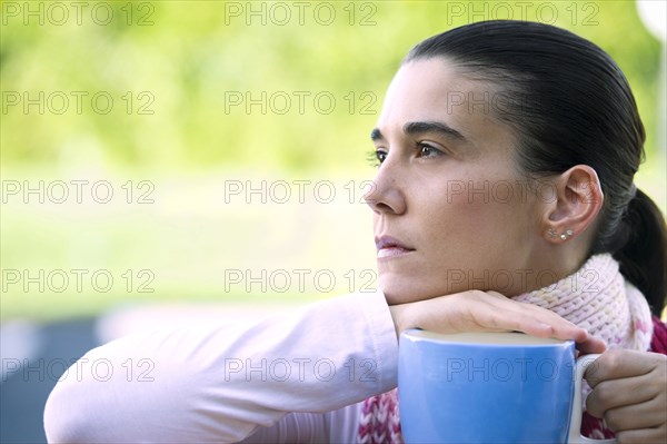 Hispanic woman drinking coffee outdoors