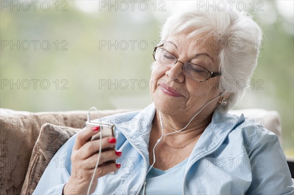 Hispanic woman listening to mp3 player