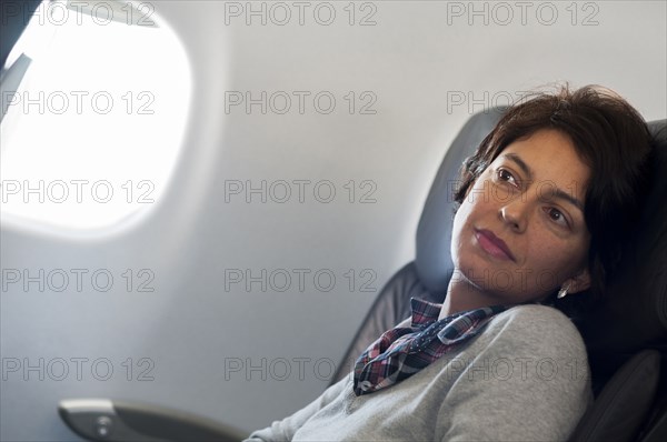 Hispanic woman sitting in airplane