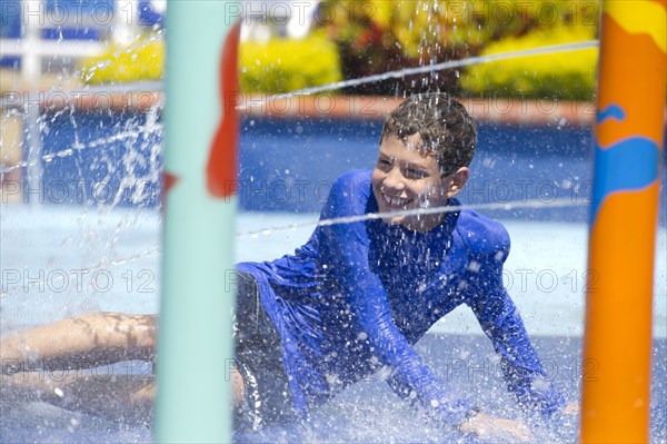 Hispanic boy playing at water park