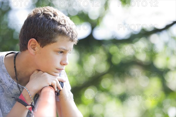 Hispanic boy sitting outdoors