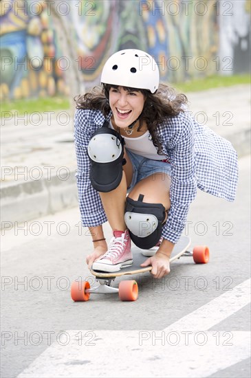 Hispanic woman riding skateboard