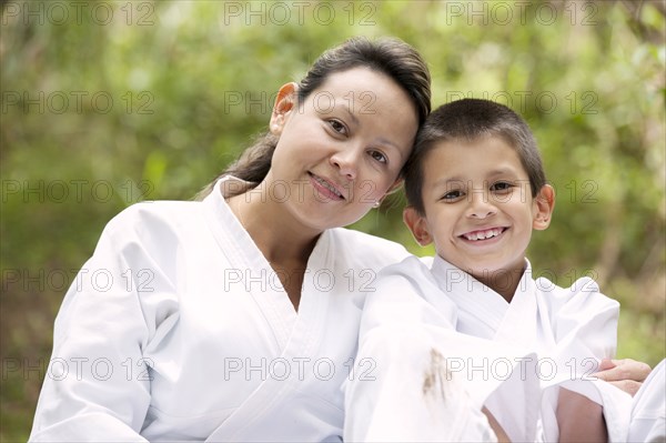Hispanic mother and son wearing martial arts robes