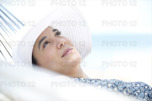 Hispanic woman relaxing in hammock