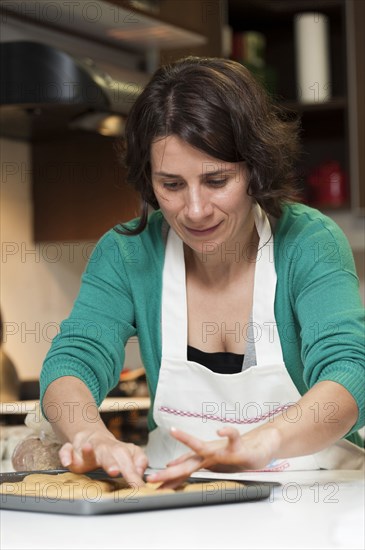 Hispanic woman baking in kitchen