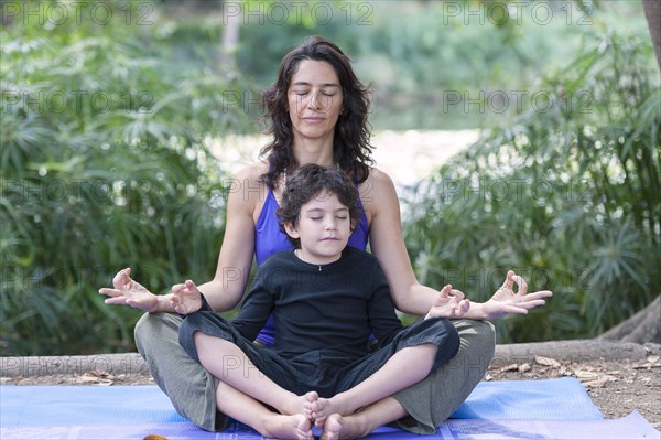 Hispanic mother and son practicing yoga