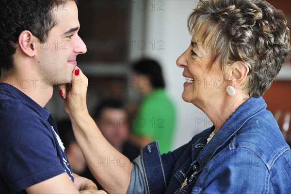 Hispanic grandmother pinching grandsons face