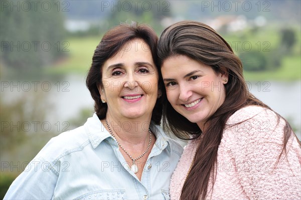 Hispanic mother and daughter smiling together