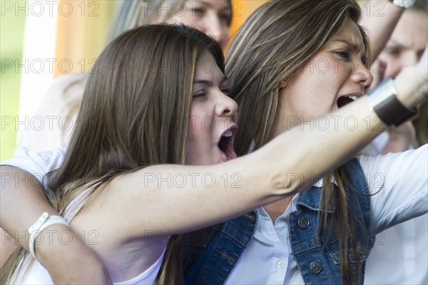 Hispanic women cheering at concert