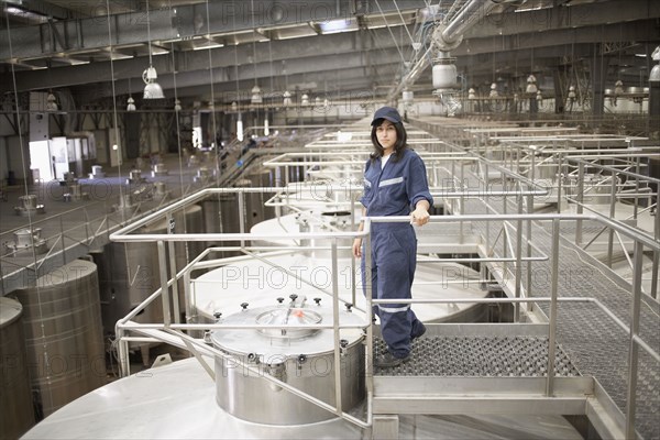 Chilean woman standing by vat at winery