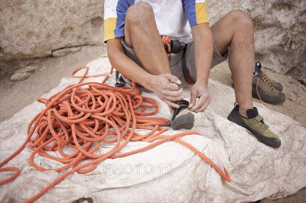 Argentinean rock climber fastening shoes