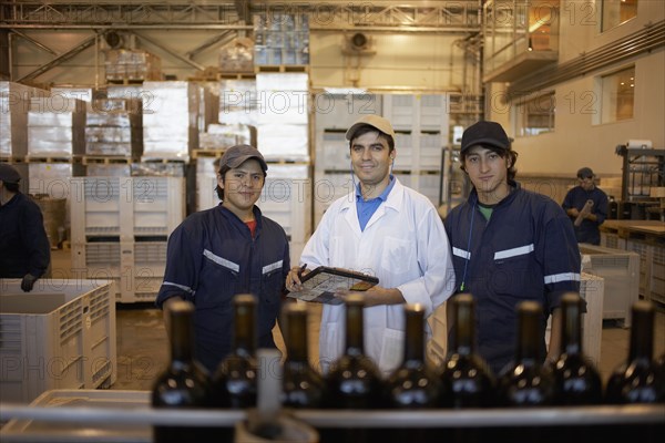 Hispanic men working in bottling factory