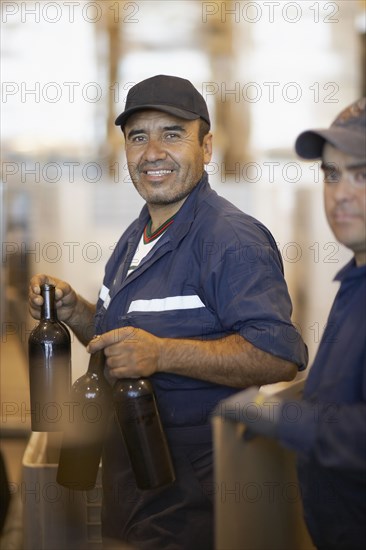 Hispanic men working in bottling factory