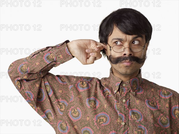 Uncertain Indian man scratching his ear